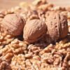 pexels-photo-33814014-33814014 Detailed image of walnuts in shell surrounded by shelled walnut halves, emphasizing natural textures.